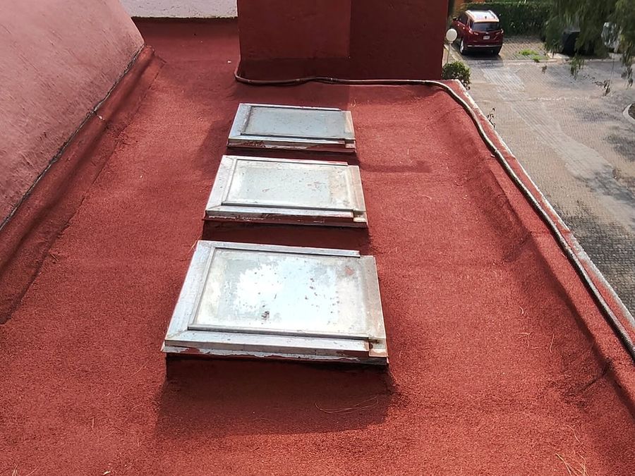 Azotea impermeabilizada con acabado rojo y tragaluces, trabajo de Inspiratta en Ciudad de México.